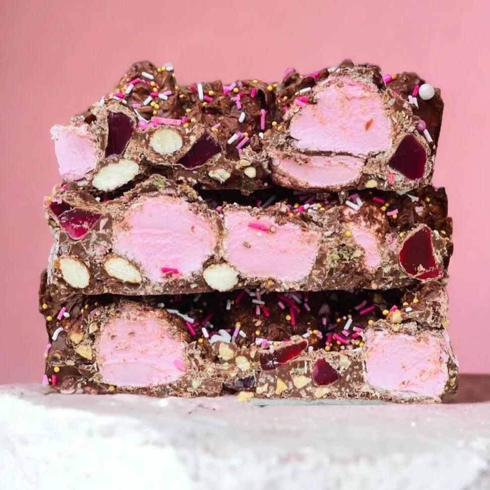 Stack of rocky road with pink marshmallows and chocolate pieces.