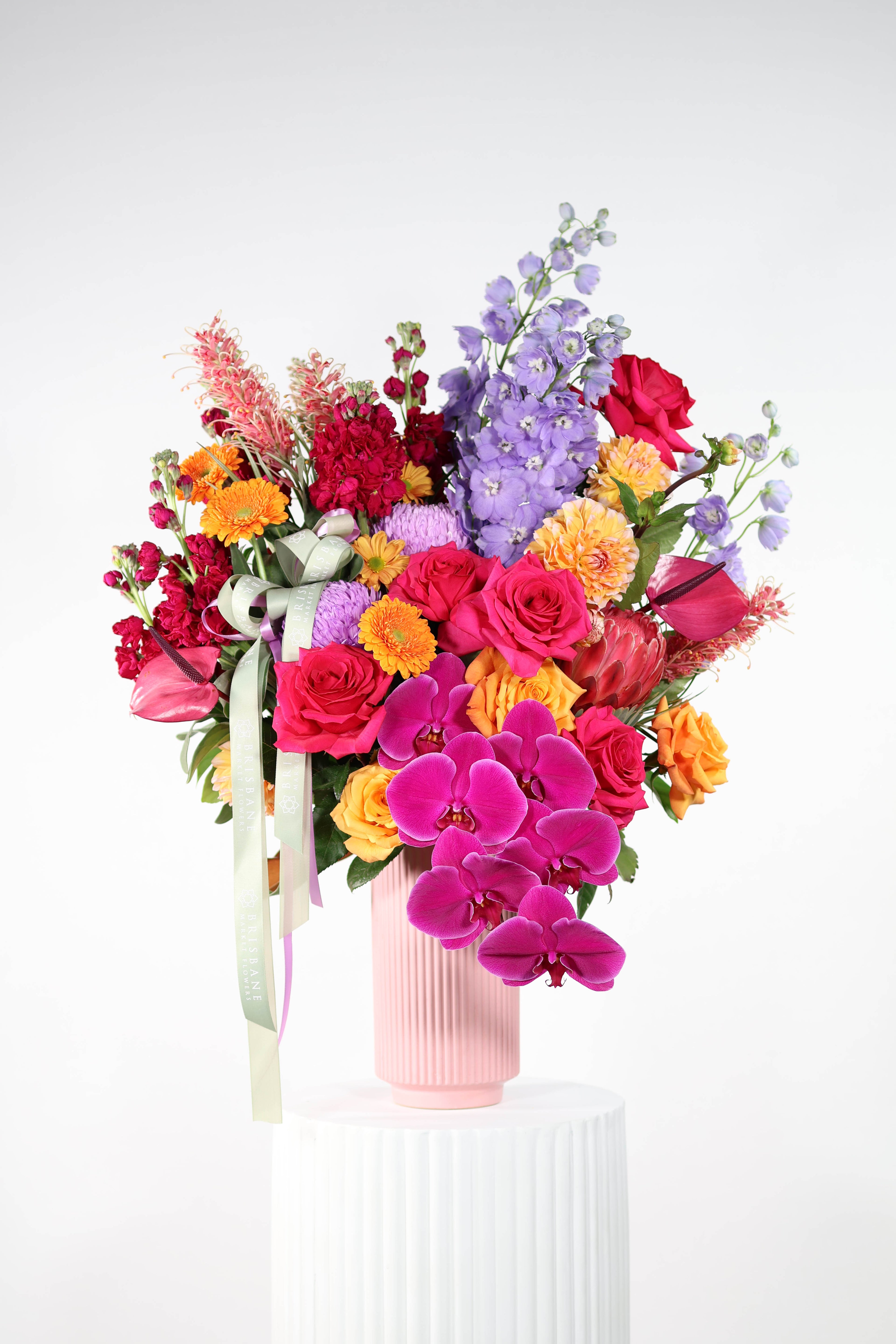 Luxury corporate flower arrangement Brisbane CBD – vibrant orange, hot pink, fuchsia, purple and gold blooms in modern vase
