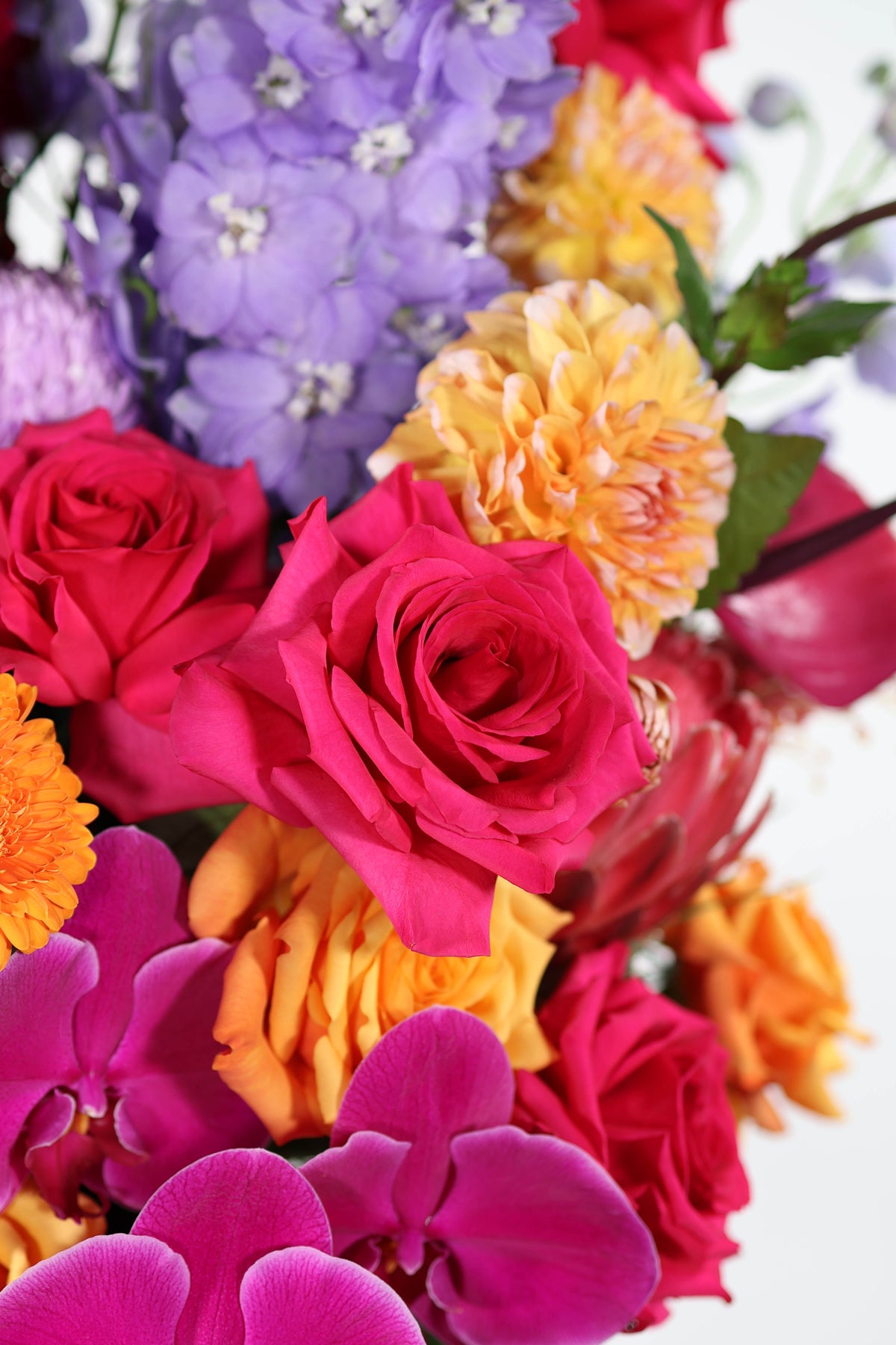 Vibrant corporate flower delivery Brisbane – luxury floral arrangement featuring fuchsia, purple and gold tones