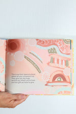 Open book with aboriginal design and text.