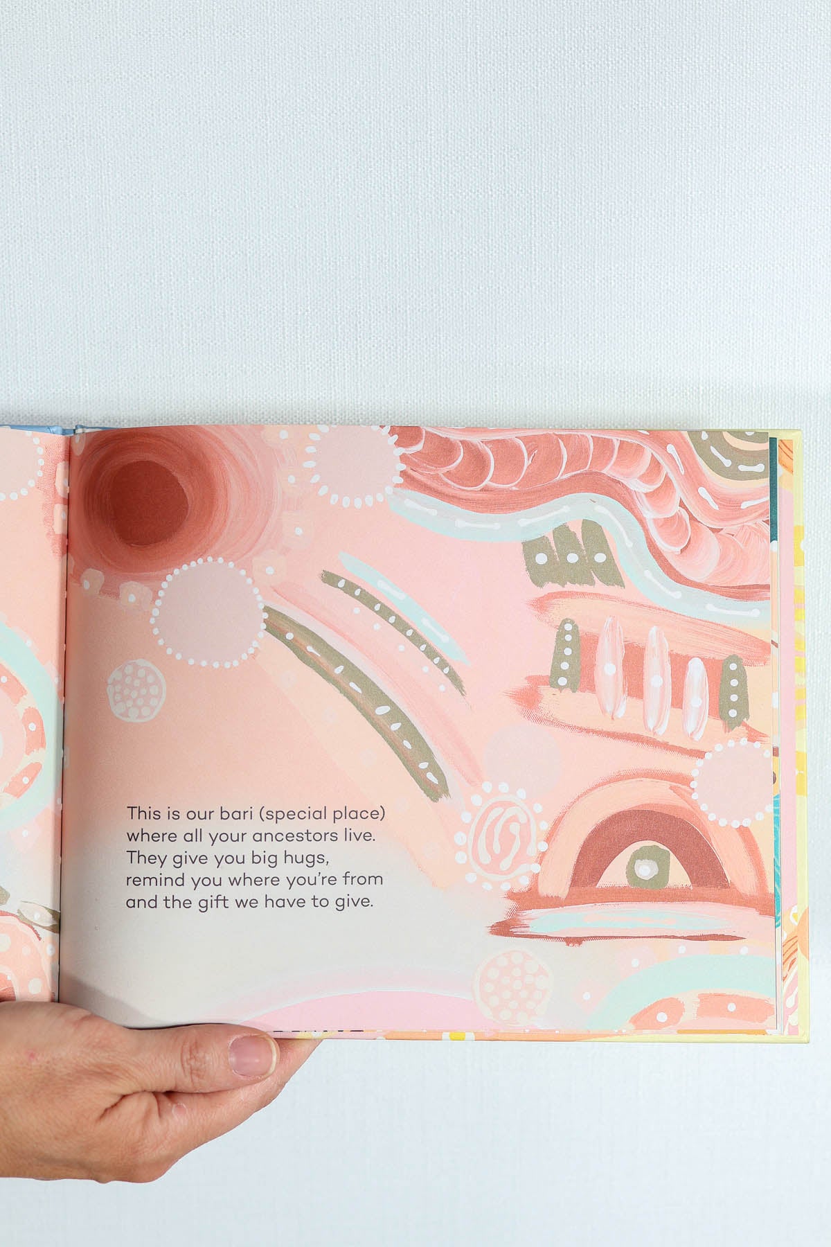 Open book with aboriginal design and text.