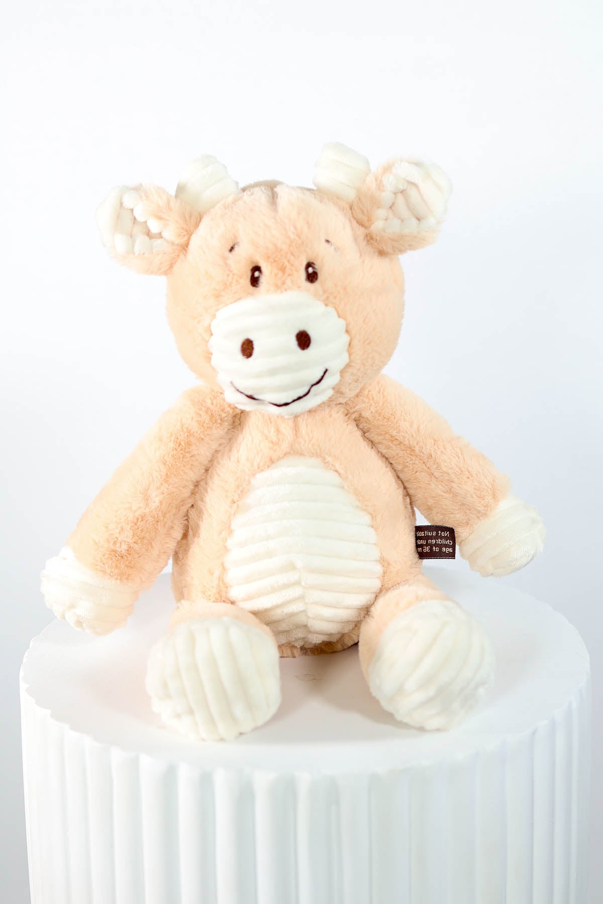 Plush giraffe toy on a white pedestal for baby hamper Brisbane.