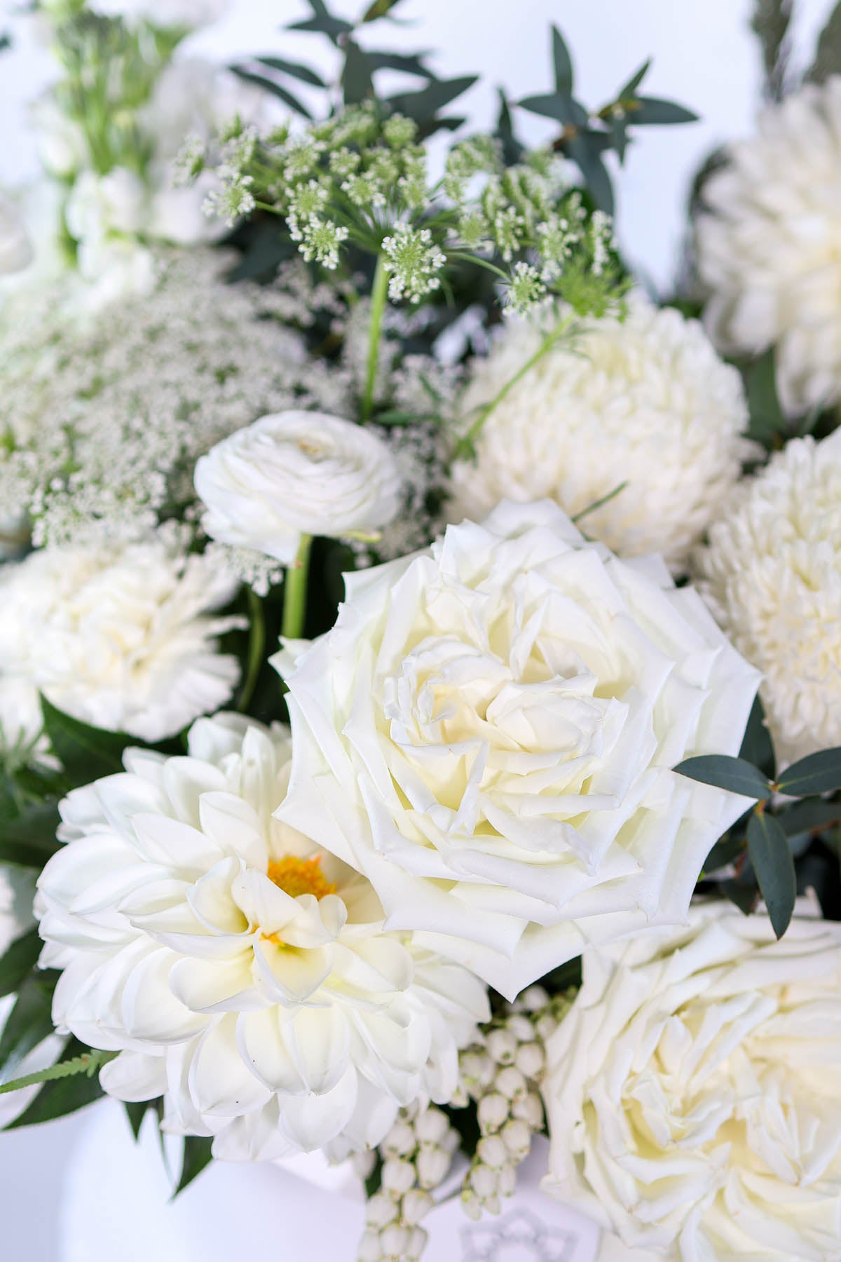 Close-up of Vaasa hatbox showing white roses, stock & Queen Anne’s lace 
