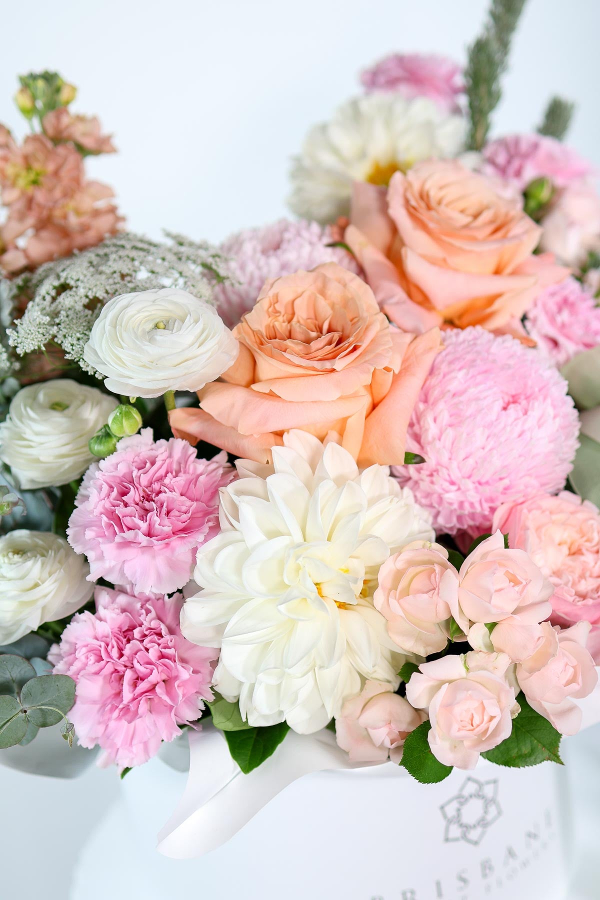 Milan pastel flower arrangement showcasing soft peach roses, pink disbuds, and white ranunculas