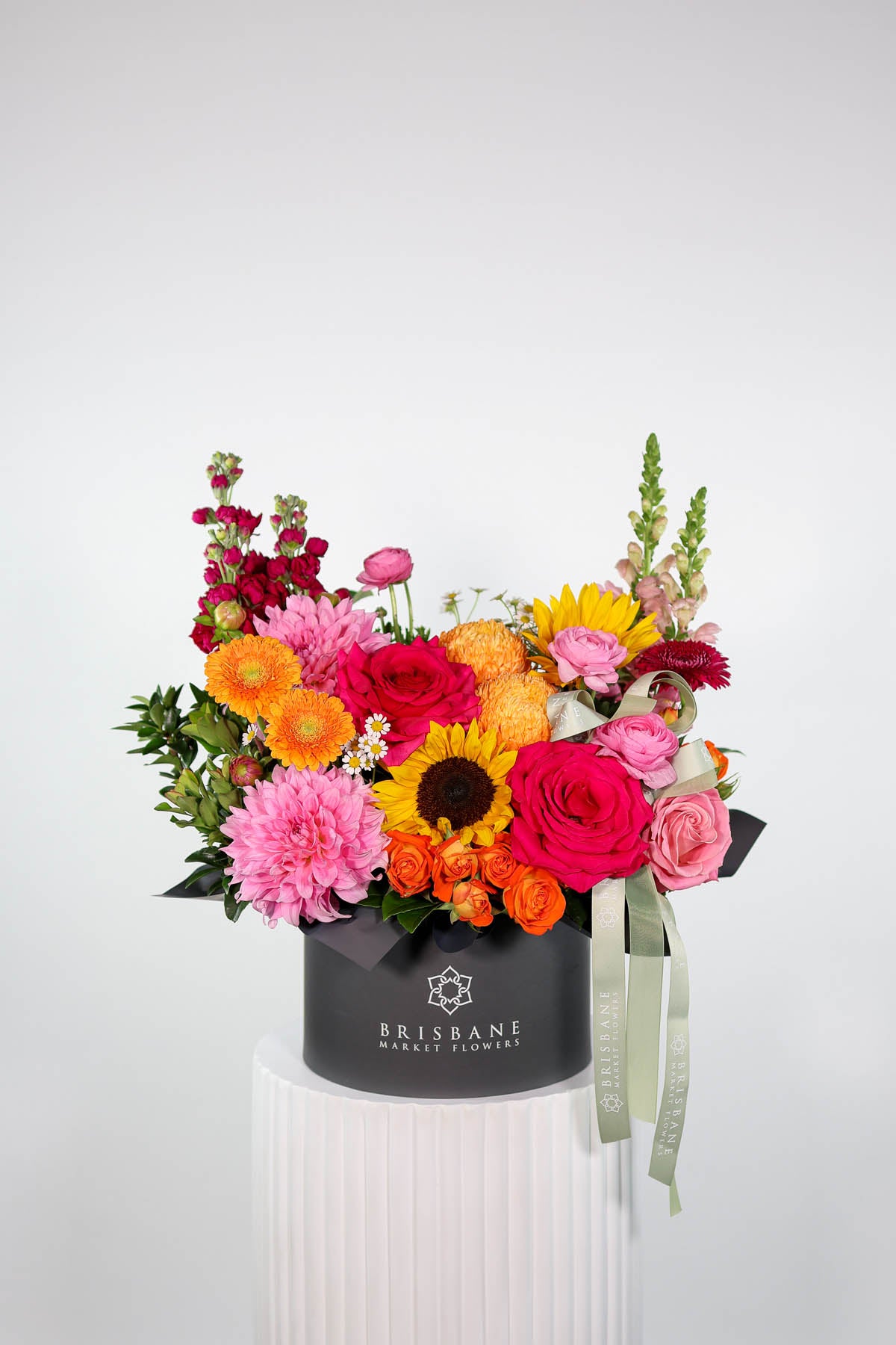 Colorful flower arrangement in a Brisbane box on a white background