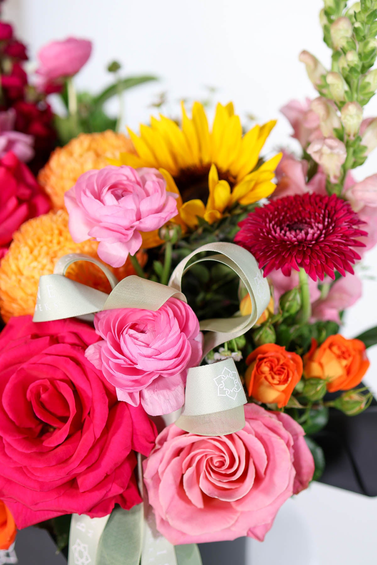 Colourful flowers with a decorative bow  from Brisbane Market Flowers on a white background