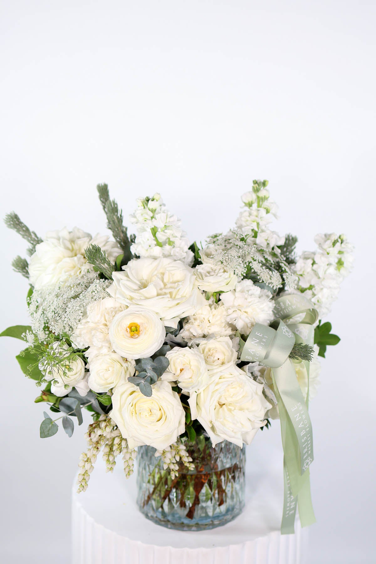 Elegant White Vase arrangement featuring white dahlias, roses, and stock with sage green foliage by Brisbane Market Flowers