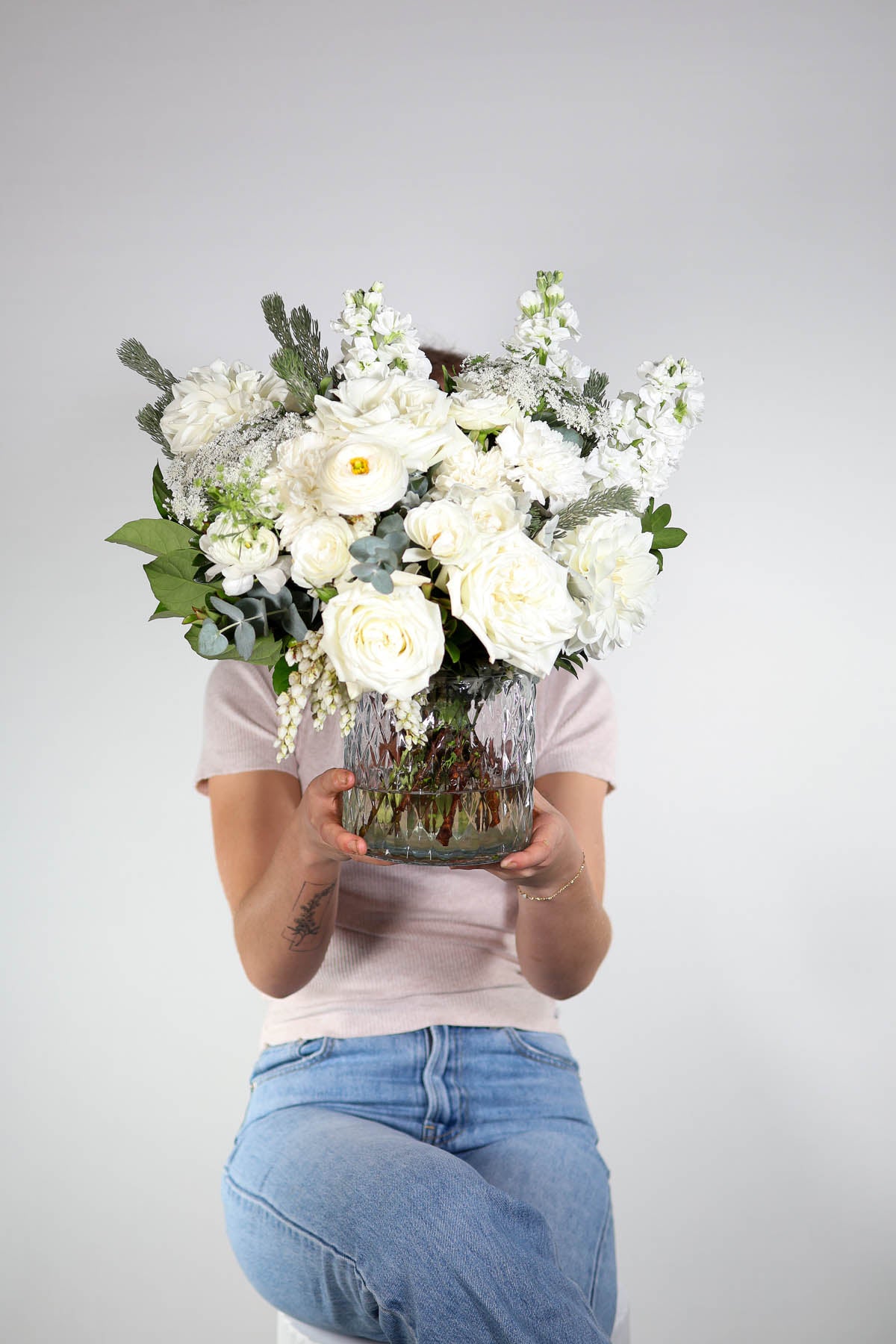 Hand-crafted white flower arrangement with Queen Anne’s lace and ivory roses, held  Brisbane floristy a woman who is a 