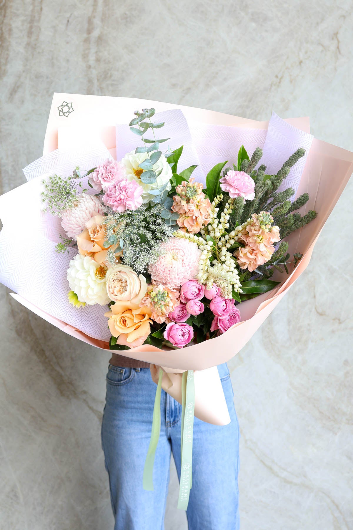 Pastel Rome bouquet of pretty flowers wrapped in pastel wrapping.