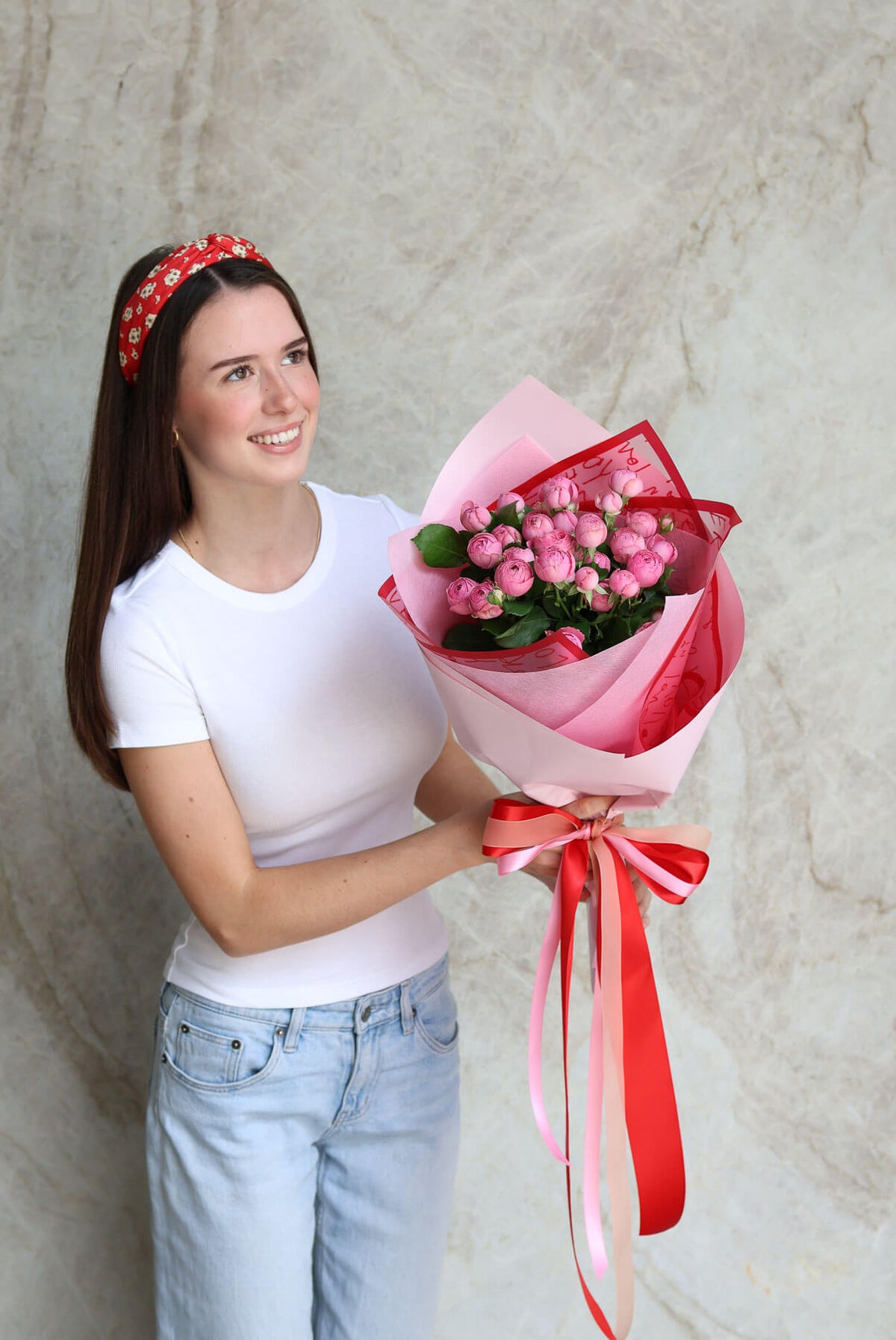 Woman holding a bouquet of pink spray roses for Brisbane flower delivery.