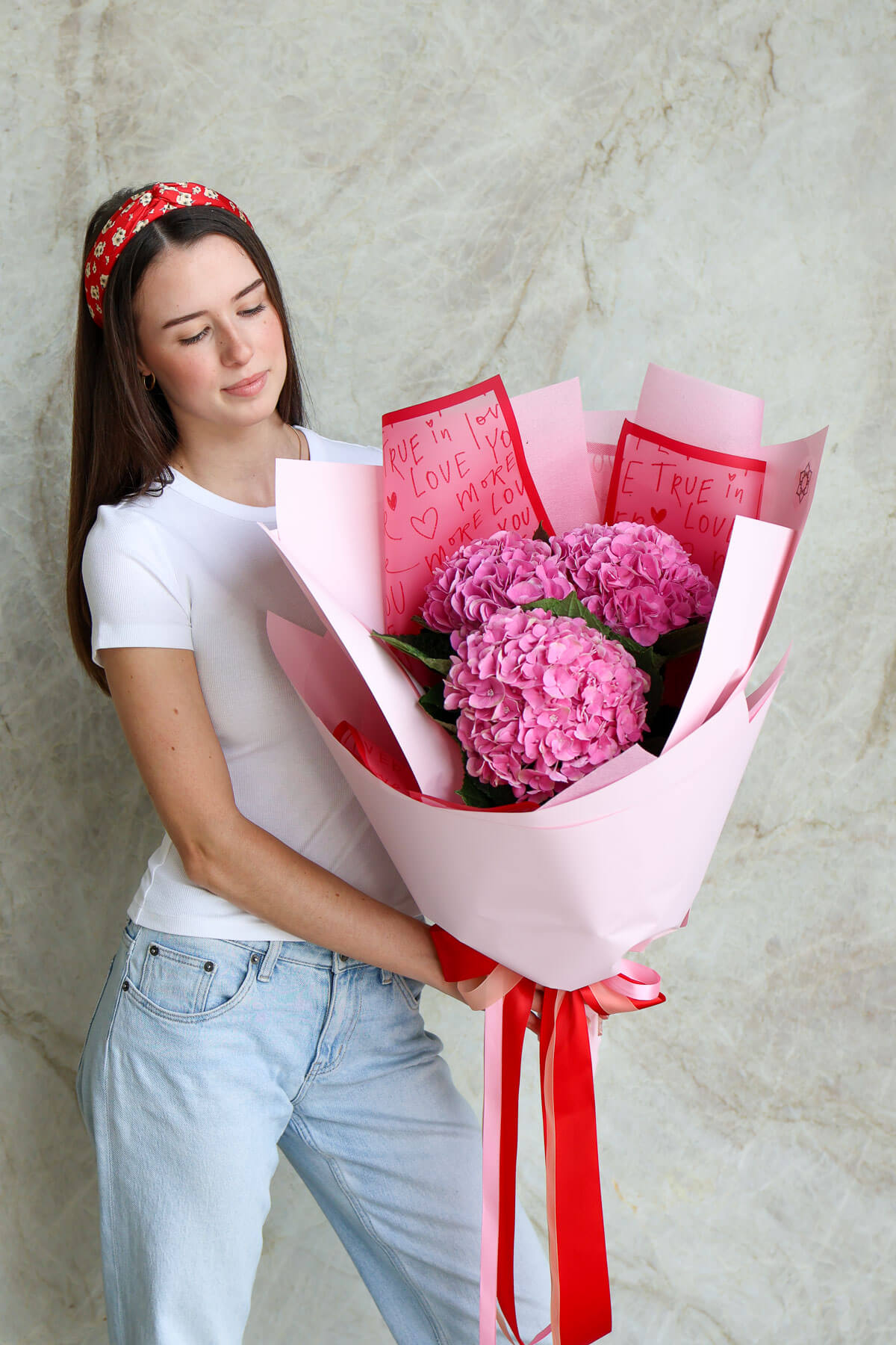 Woman holding hydrangea bouquet with premium blooms for Valentine’s Day.
