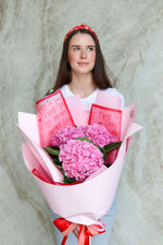 Woman holding a bouquet of pink hydrangea flowers for Valentine's Day.