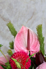 Close-up of a Valentine's Hatbox with pink Anthurium and red Dahlia flowers.