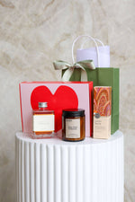 Gift items including a cocktail bottle, hand cream,candle, and 6 pack of Brownies with heart design.