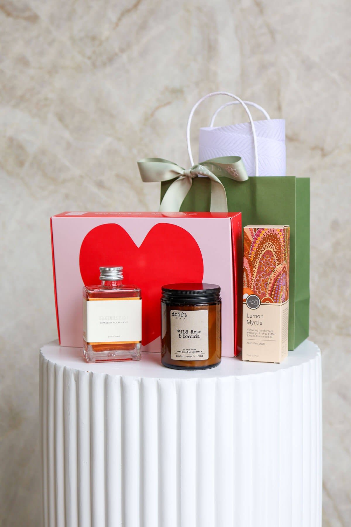 Gift items including a cocktail bottle, hand cream,candle, and 6 pack of Brownies with heart design.