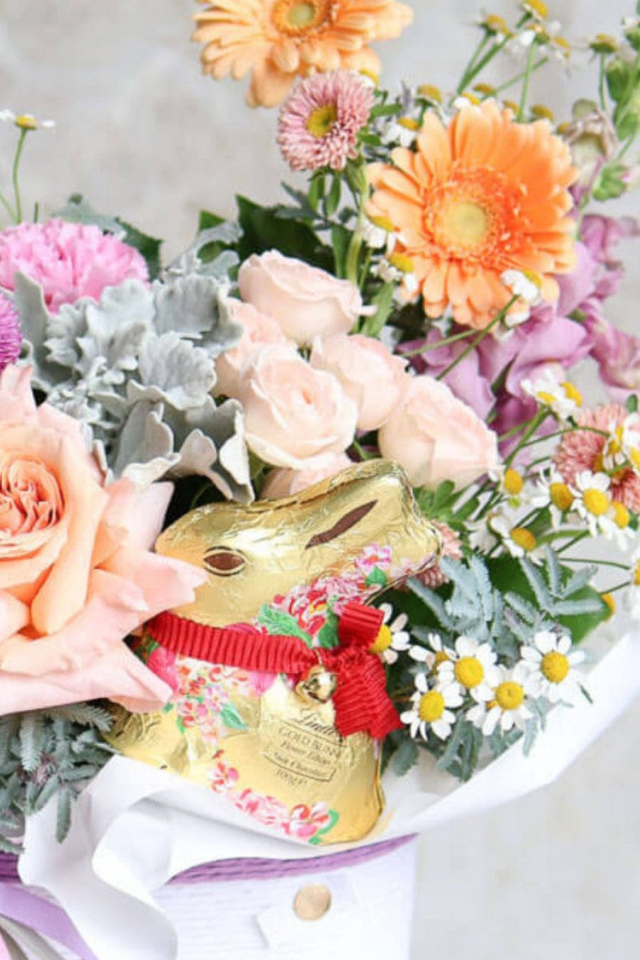Easte box of flowers with a gold Lindt bunny attached for gift giving.