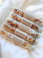 Multiple glass tubes of bath and foot soak with visible ingredients .