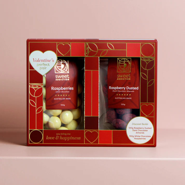Gift set with 'Sweet Addiction' raspberry products in a decorative box on a pink background