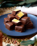 Honeycomb chocolates stacked up on a blue plate.