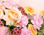 Close-up of a bouquet of flowers with yellow, pink, and green colors.