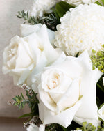 Close up of white roses in a handcrafted wreath and floral tribute. remembrance