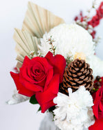 Close-up of Noelle vase arrangement showing roses, dried accents, and seasonal greenery